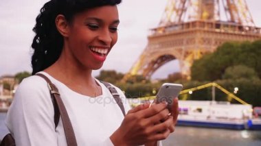 Köprüde duran ve smartphone kullanarak gülümseyen iş kadını