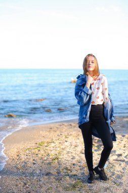 Çekici kız sahil boyunca yürür ve neşeyle kum üzerinde aptallar