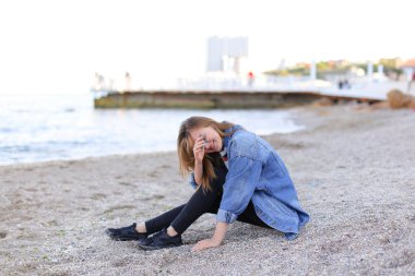 Dinlenme, deniz kenarında oturan ve b kameraya poz güzel kız