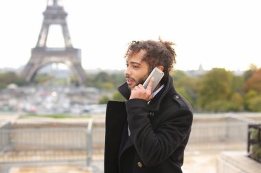 Arap damat smartphone cep telefonu ile yakın Eifel Kulesi yavaş mot konuşuyor