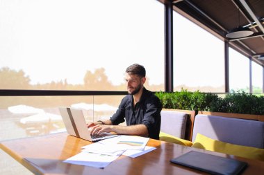 Miktar arazi kafeterya masada kağıtları ve dizüstü bilgisayar ile çalışma.