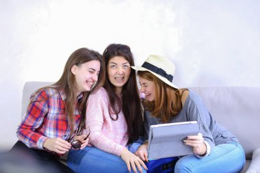 Yakın arkadaşlar tablet kullanmak ve iyi eğlenceler, ro koltukta oturmak