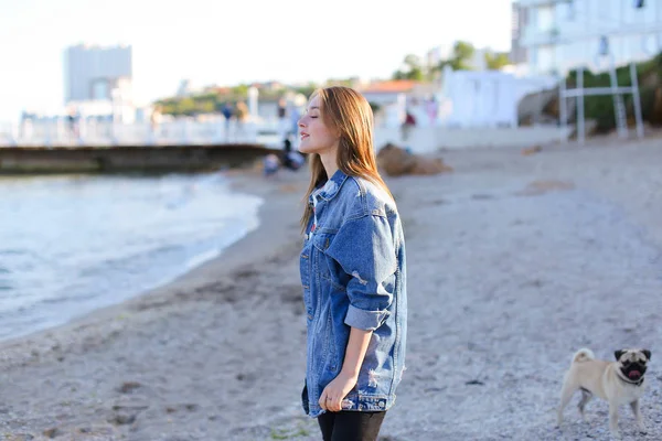 Portrait of cute young woman who poses and smiles in camera, sta