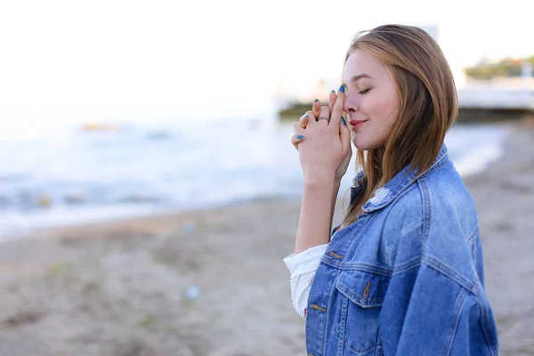 Mujer bonita sonríe fácilmente y mira al horizonte, de pie en sho — Foto de Stock