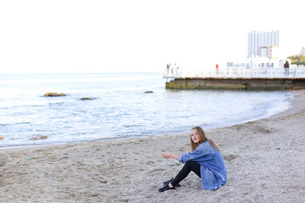 Mulher bonita relaxa sentado na praia e goza de vista o — Fotografia de Stock