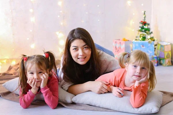 Ładna kobieta i dwoje dzieci małe dziewczynki, pozowanie na kamery i — Zdjęcie stockowe