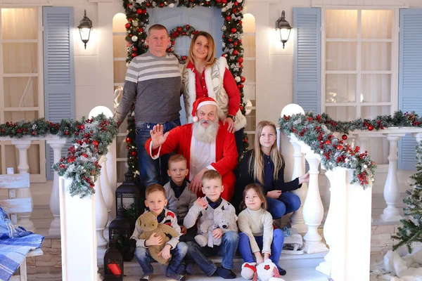 Famille amicale et Père Noël posant pour la caméra sur le porche de ho — Photo