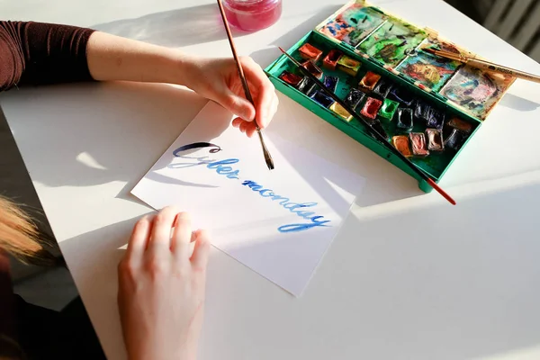 Calligraphe féminine crée inscription à vendre, à l'aide de brosses — Photo