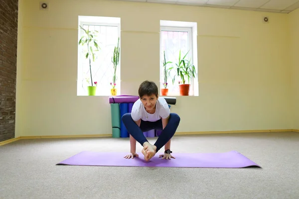 Kvinna med europeiskt utseende bedriver yoga i fitnesstudion. — Stockfoto