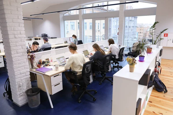 Büroflächen mitten im Arbeitstag mit Menschen, die in die Welt eintauchen. — Stockfoto