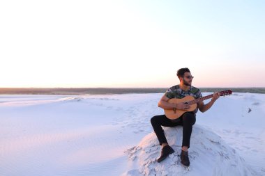 Sevimli genç erkek Arap ses gitar, Hill'de oturan sahiptir