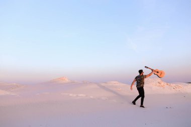 Arap adam çöl güzelliği ile ilham gider ve gitar çi çalış