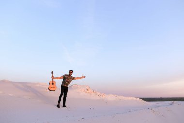Arap adam çöl güzelliği ile ilham gider ve gitar çi çalış