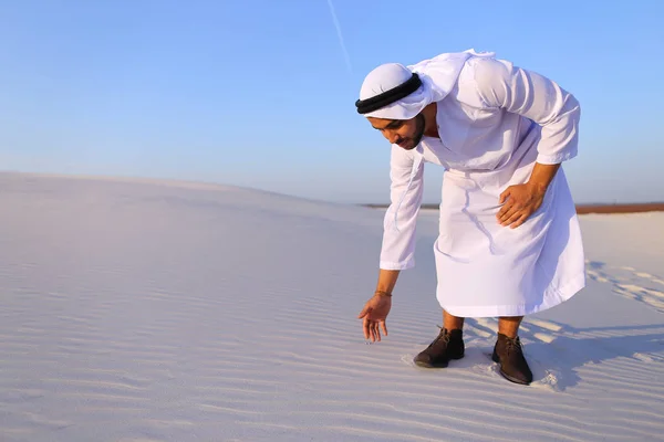 Hombre musulmán desarrolla arena a lo largo del viento y de pie en medio de — Foto de Stock