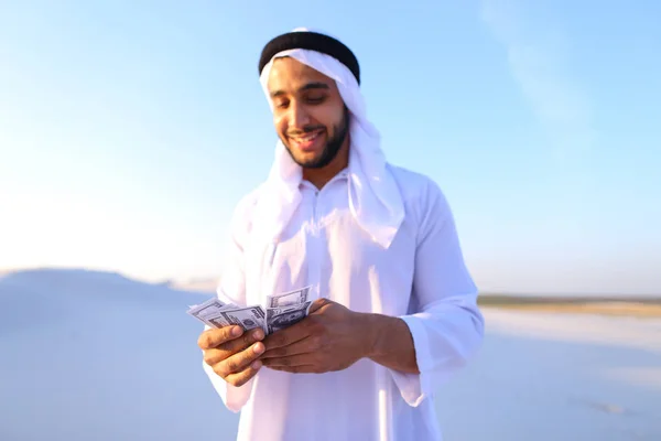 Sceicco arabo di successo considera le banconote e felice, in piedi i — Foto Stock