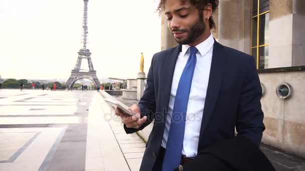 Латиноамериканец звонит партнеру с телефоном возле Эйфелевой башни в замедленной съемке . — стоковое видео