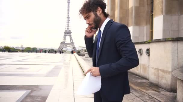 Arabischer Geschäftsmann streitet mit Partner per Smartphone in der Nähe des Eiffelturms. — Stockvideo