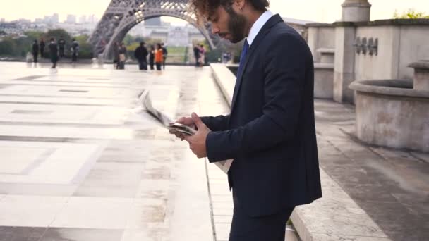 Jornalista hispânico perto da Torre Eiffel lendo jornal e olhando para assistir em câmera lenta . . — Vídeo de Stock