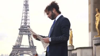 Melez pressman gazete makalesi Eiffel Tower yakınındaki okuma.