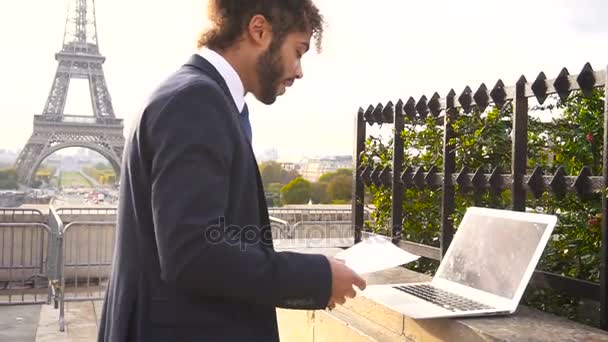 Mulatto theatre actor preparing for performance with laptop near Eiffel Tower in slow motion. — Stock Video