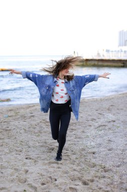 Sevimli kadın gülümseme ile teşkil etmektedir ve deniz kıyı savaş yürür