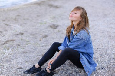 Bakıyor düşünceli kadın deniz manzarası ve sörf için dinler oturan