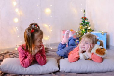 Komik küçük kız gülmek ve konuş, katta ve üzerinde yalan poz