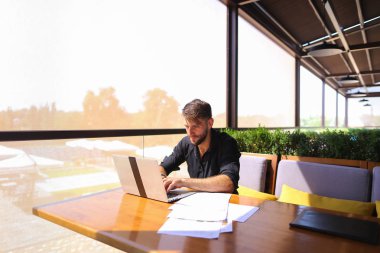 Başarılı foreman kafede dizüstü ve belgeleri kullanma.