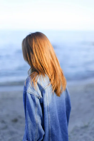 Pretty girl tourist who stands on seashore and develops hair, en — Stock Photo, Image