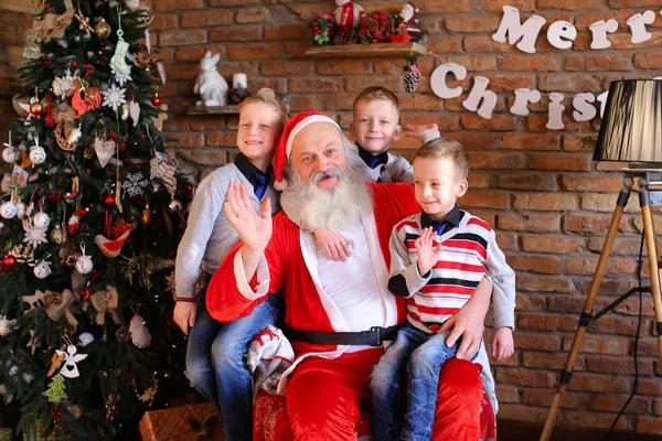 Papai Noel e irmãos enviar saudações para a câmera em lindamente — Fotografia de Stock