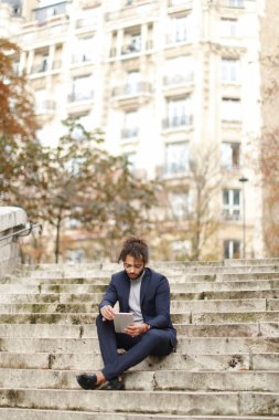 Yakışıklı yarım Nijeryalı adam adımları tablete tarafından kızla sohbet