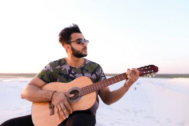 Arap yakışıklı genç gitar mi Hill'de oturan, ayarlar