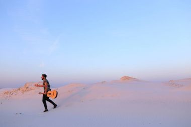 Arap adam çöl güzelliği ile ilham gider ve gitar çi çalış