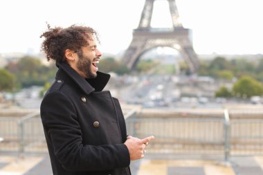 Melez gülen adam Eyfel Kulesi ile smartphone