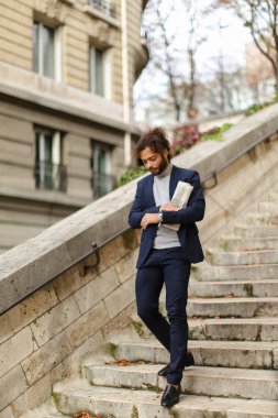 Gazete adımlarla yürürken yakışıklı mix kan adam.