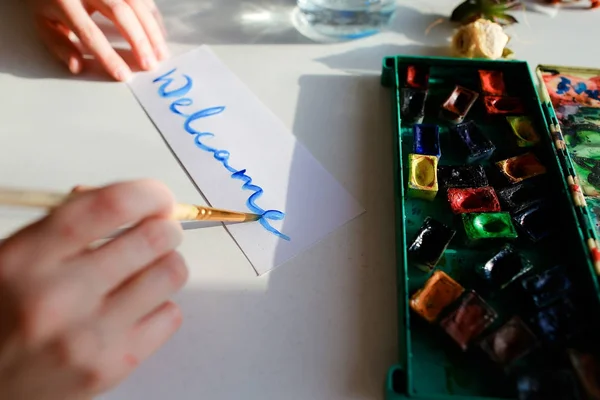 Jovem pintora escreve aquarela escrevendo no papel, sentado — Fotografia de Stock