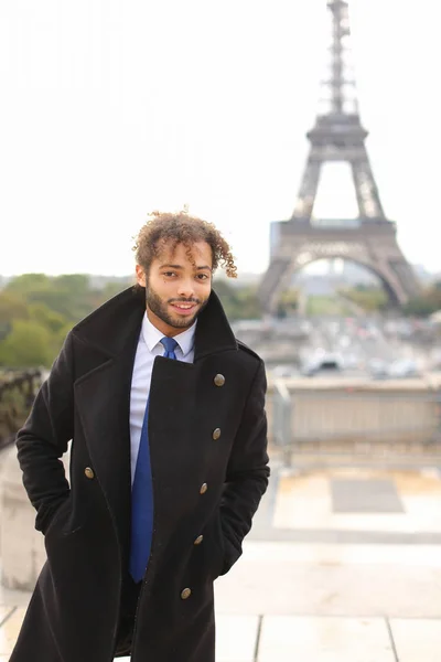 Mulato modelo masculino sorrindo perto da Torre Eiffel . — Fotografia de Stock