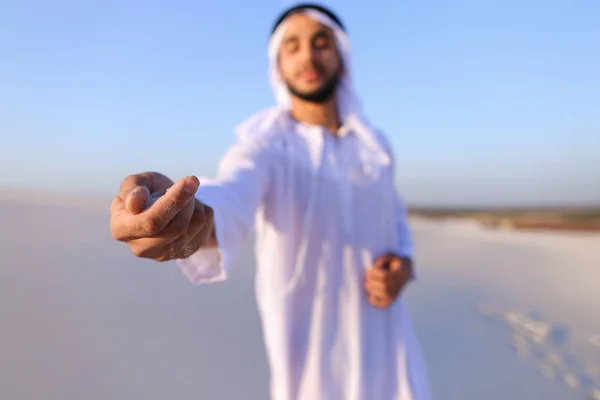 Close-up shot of portrait and hands of young Arab guy in sandy d — Stock Photo, Image