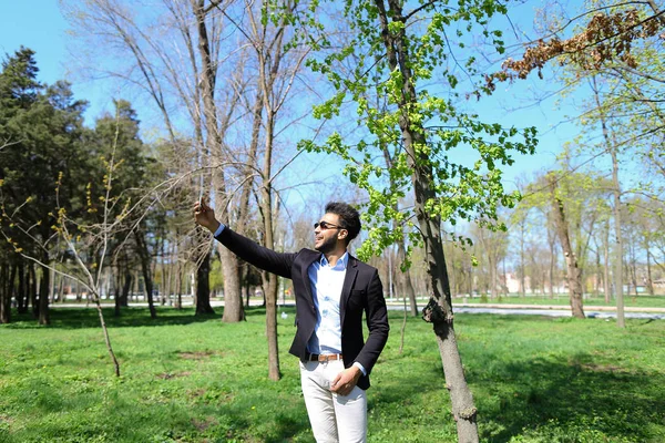 Muchacho musulmán probando nuevo teléfono y mostrando señal de paz de la mano en cámara lenta — Foto de Stock