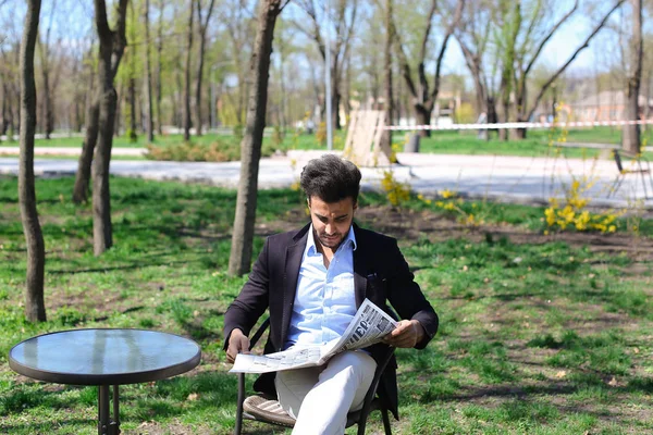 Atractivo hombre leyendo el periódico en el parque, cámara lenta . — Foto de Stock