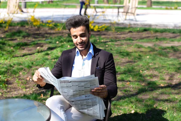 Αραβική μόλις αγόρασα νέα καθημερινή εφημερίδα και ανάγνωση στο πάρκο. — Φωτογραφία Αρχείου