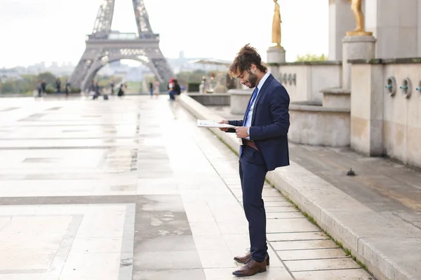 Periodista hispano cerca de Torre Eiffel leyendo periódico y — Foto de Stock