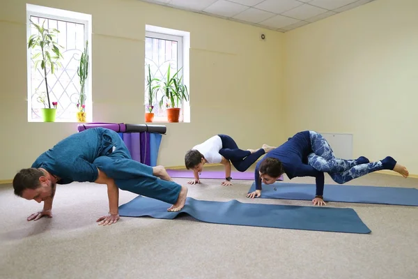 Tres jóvenes haciendo yoga en el gimnasio . —  Fotos de Stock