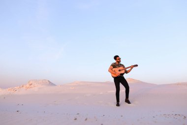Arap adam çöl güzelliği ile ilham gider ve gitar çi çalış
