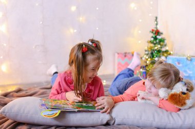 Sevimli küçük kızlar birlikte oynamak ve sohbet, yerde yatıyor ve