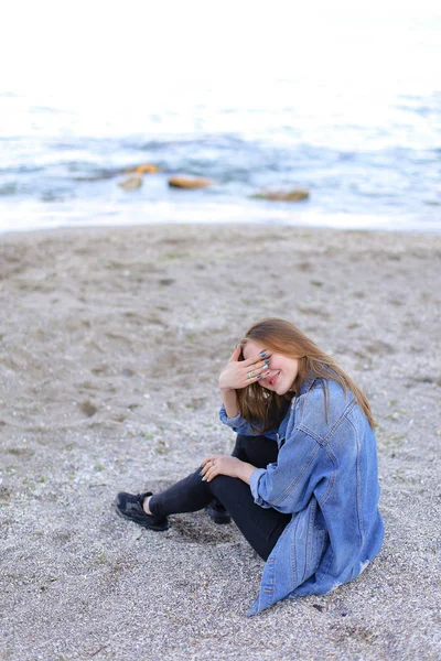 美丽的姑娘休息，坐在海边，并构成 b 上的相机上 — 图库照片