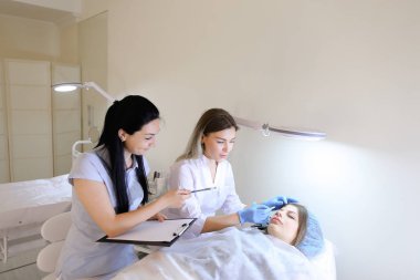 Kadın kaş dövme ana kız öğrenci c ile çalışmak için öğretir