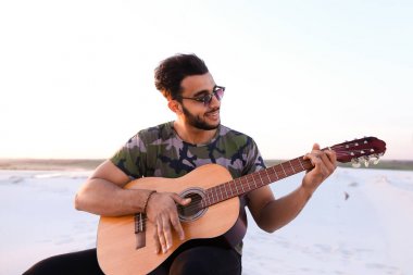 Arap yakışıklı genç gitar mi Hill'de oturan, ayarlar