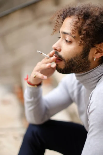 Молодий мультфільм курець кашляє на сходинках з цигаркою . — стокове фото