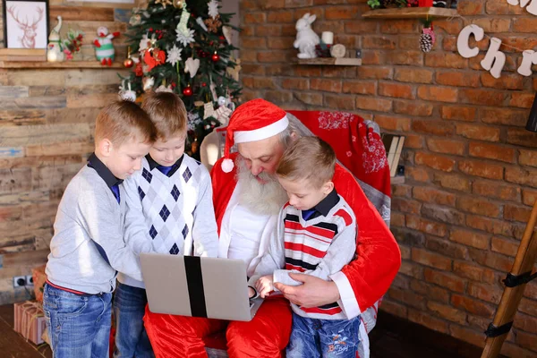 Amigos cercanos de niños con Santa Claus usan laptop en Cristo — Foto de Stock